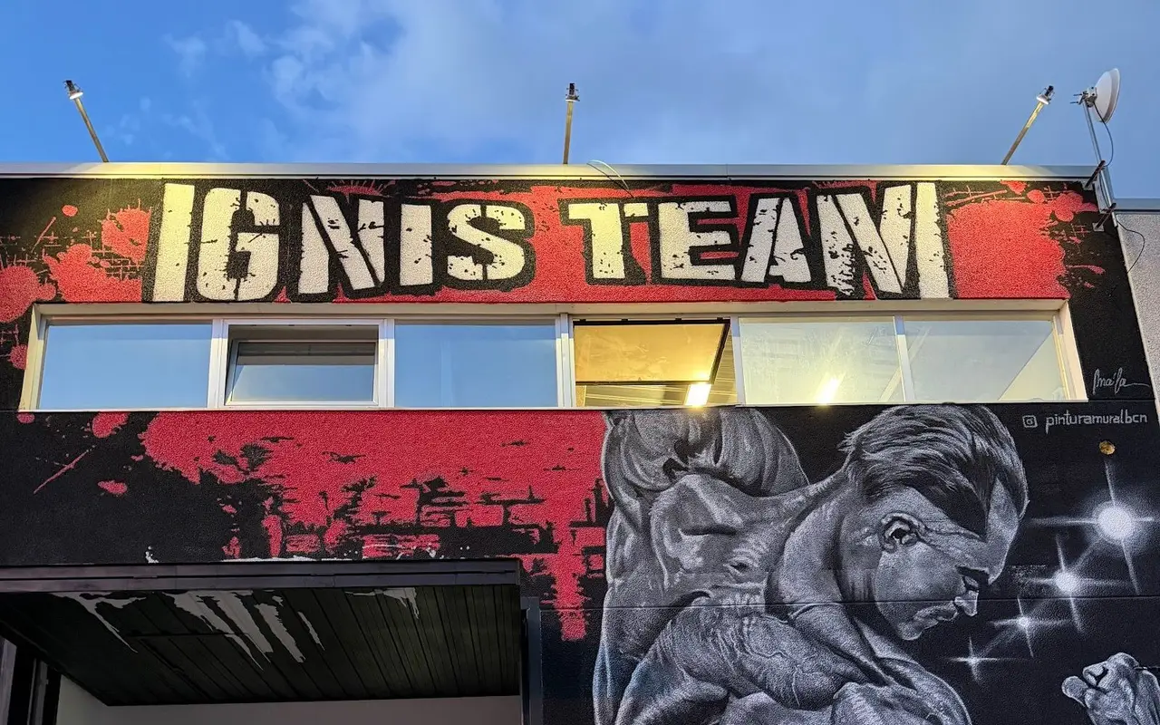 Fachada de la nave de Ignis Gym con el rótulo Ignis Team y un mural de culturista